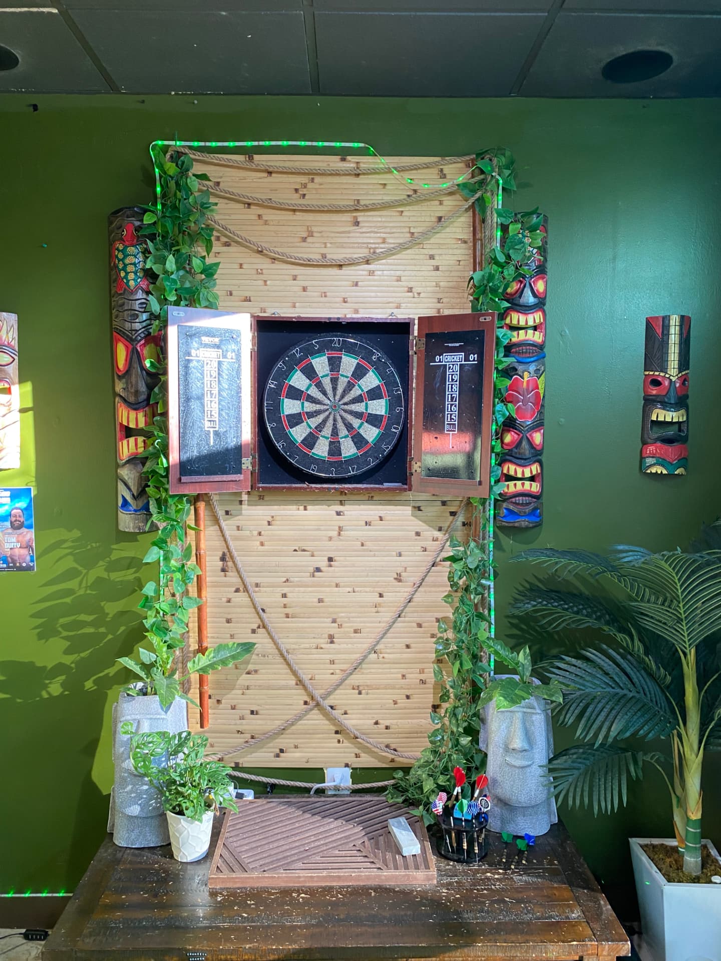 Tiki-decorated dartboard station used for the Thursday dart tournament